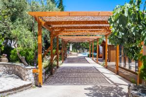 a wooden pergola over a walkway at Apanema Mindfulness Resort Lefkada - ultra fast Starlink WiFi in 2025 in Asprogerakata
