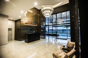 a living room with a couch and a chandelier at High Street Apartments Toowong in Brisbane