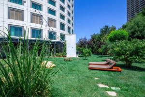 einen Garten mit Stühlen im Gras neben einem Gebäude in der Unterkunft Crowne Plaza Istanbul Oryapark by IHG in Istanbul