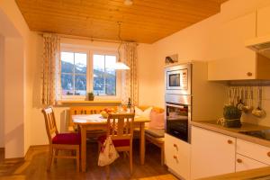 巴爾德赫旺的住宿－Alpenrösle，一间带桌子的厨房和一间餐厅
