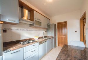 Una cocina con gabinetes blancos y encimera. en Villa Ritoša, a beautiful pool villa surrounded by greenery, en Trviž