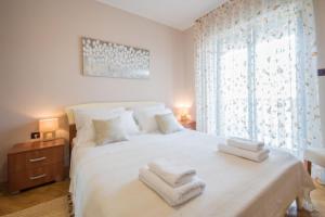 Un dormitorio con una cama blanca con toallas. en Villa Ritoša, a beautiful pool villa surrounded by greenery, en Trviž 23 fotos más