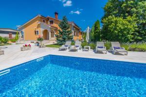 una piscina frente a una casa en Villa Ritoša, a beautiful pool villa surrounded by greenery, en Trviž