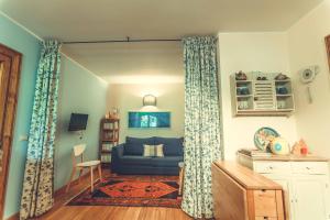 a living room with a blue couch and curtains at Il Boschetto Di Castagni in Soriano nel Cimino
