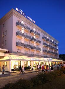 ein Hotelgebäude mit Leuten, die draußen stehen in der Unterkunft Hotel Pillon in Bibione