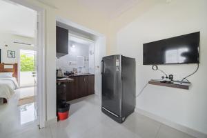 a kitchen with a refrigerator and a tv on the wall at Stayhome Suites in Bengaluru