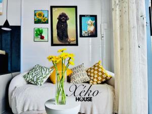 a living room with a couch and a vase with flowers at Nhà có sân thượng cây xanh view đẹp không gian yên tĩnh in Xóm Bình Nguyên