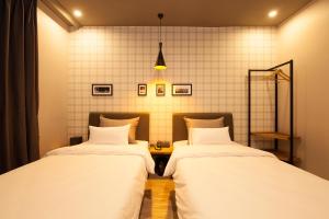 dwa łóżka z białą pościelą w pokoju w obiekcie Hotel Gray w mieście Changwon