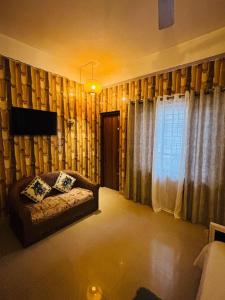 a living room with a couch and a window at The Hushe in Guwahati +2 photos