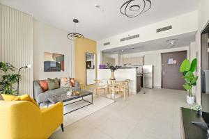 アブダビにあるSilkhaus Signature 1BDR at Najmat in Al Reem Islandのソファとテーブルのあるリビングルーム