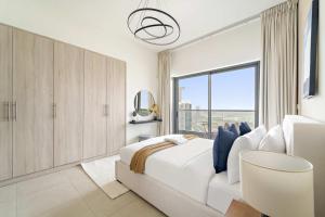 アブダビにあるSilkhaus Signature 1BDR at Najmat in Al Reem Islandの白いベッドと大きな窓のある寝室