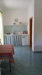 eine Küche mit einem Tisch und einem weißen Kühlschrank in der Unterkunft Casa Ischia in Ischia
