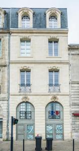 a large stone building with windows and doors at L'annexe Bordeaux Traditions in Bordeaux