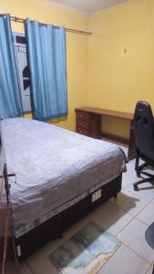 a bedroom with a bed and a desk and a chair at Casa 3 quartos em Juruti in Juruti +3 photos