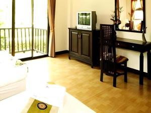 a living room with a television and a chair at The Forest Home Resort in Nakhon Nayok