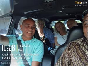 un grupo de personas sentadas en la parte trasera de un coche en UJ tour & travel, en Surabaya
