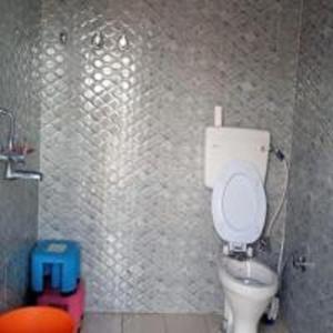 a bathroom with a white toilet in a stall at Sunflower Homestay By StayApart in Kibar