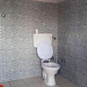 a bathroom with a white toilet in a room at Sunflower Homestay By StayApart in Kibar