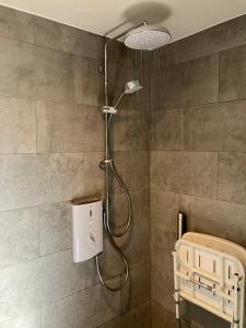 a shower with a shower head in a bathroom at Chez Little Black Cat in Patrington +23 photos