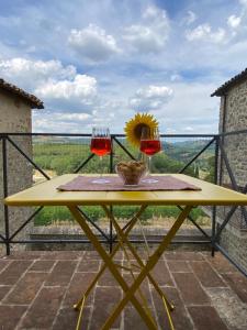 a table with two glasses of wine on a balcony at Appartamento Balcone sulla vigna Borgo Solfagnano in Solfagnano Parlesca +24 photos