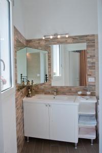 Un baño con un lavabo blanco y un espejo. en LI CURTI B&B, en Melissano 125 fotos más