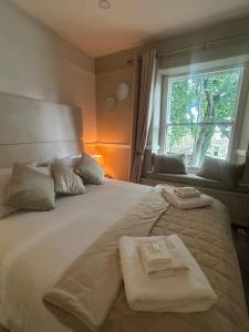 a large white bed with two folded towels on it at Corbridge Apartment in Corbridge