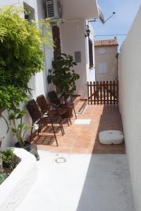 - un ensemble de chaises assises sur une terrasse dans l'établissement Casa Pina, à Cala Gonone
