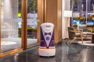 a purple and white robot standing in a lobby at 武汉汉口金融中心万象城漫心酒店 in Wuhan