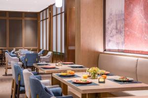 a row of tables and chairs in a restaurant at 武汉汉口金融中心万象城漫心酒店 in Wuhan