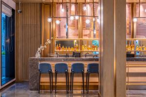 a bar with blue stools in a restaurant at 武汉汉口金融中心万象城漫心酒店 in Wuhan