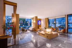 a lobby of a hotel with tables and chairs at 武汉汉口金融中心万象城漫心酒店 in Wuhan