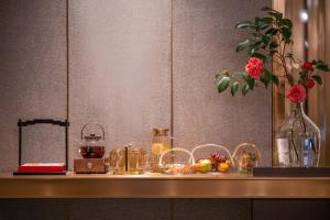 a counter with a vase of flowers and other items at 武汉汉口金融中心万象城漫心酒店 in Wuhan