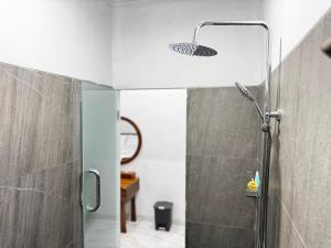 a bathroom with a shower with a glass door at Dé Kamala Bali in Nusa Dua