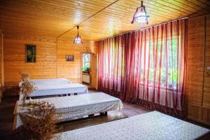 カメンノモスツキーにあるGuesthouse Zhili-Byliの木造の建物内のベッド3台付きの部屋