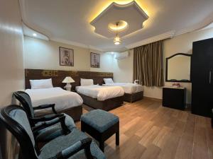 GizaComplex hotel view的有两张床和一把椅子的酒店房间