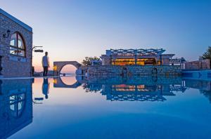 a man standing next to a body of water at Contaratos Beach Hotel in Naousa