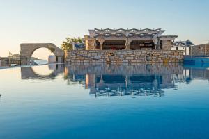 a building sitting on top of a body of water at Contaratos Beach Hotel in Naousa