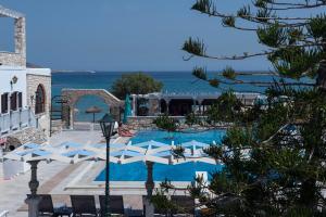 a resort with a pool and the ocean in the background at Contaratos Beach Hotel in Naousa