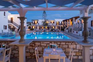 a resort with a pool and tables and chairs at Contaratos Beach Hotel in Naousa