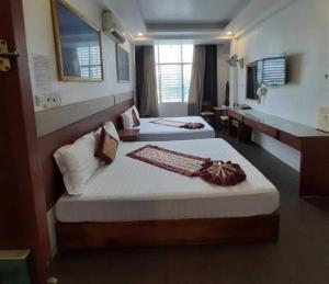 a hotel room with two beds and a sink at Belvilla in District 8 Near Ben Thanh Market Formerly Eva Hotel in Ho Chi Minh City
