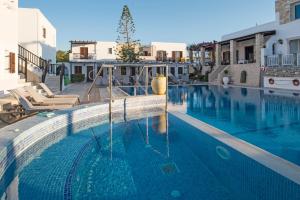 a swimming pool with blue water in a building at Contaratos Beach Hotel in Naousa