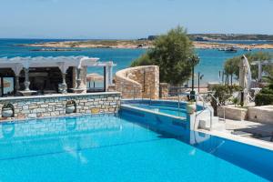 a swimming pool with a view of the water at Contaratos Beach Hotel in Naousa