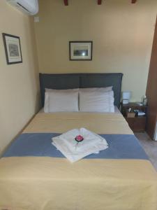 a bed with a bouquet of flowers on it at En Zar Ξυλόκαστρο in Áno Kamárion
