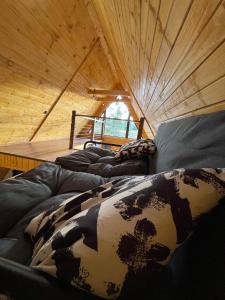a group of beds in a room with a roof at Cabană Panoramic Aframe in Dealu Negru