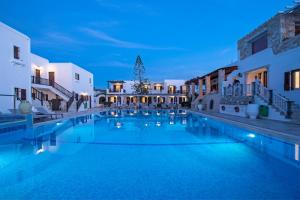 a swimming pool in a hotel at night at Contaratos Beach Hotel in Naousa