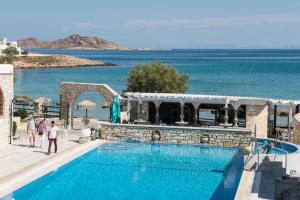 a swimming pool with the ocean in the background at Contaratos Beach Hotel in Naousa
