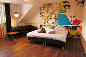 a bedroom with a bed and a couch at Pension zur Sonne 24/7 in Poppenhausen