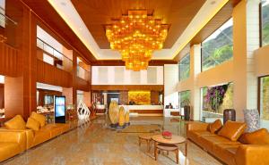 a lobby with couches and a chandelier at Amber Dale Luxury Hotel & Spa, Munnar in Munnar
