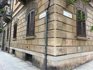 un edificio in mattoni con due finestre e una strada di Leoni di Sicilia a Palermo