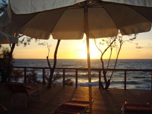 an umbrella and chairs on a deck with the ocean at Cala Dei Mori in Livorno